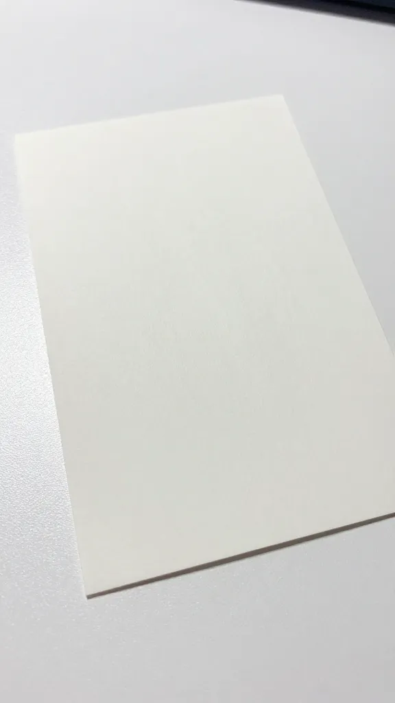 Closeup of a single cardstock sheet on a white table, edge crisp