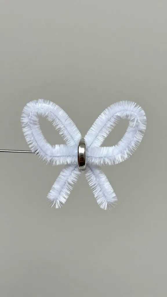 Closeup of a single pipe cleaner charm with glitter on neutral background