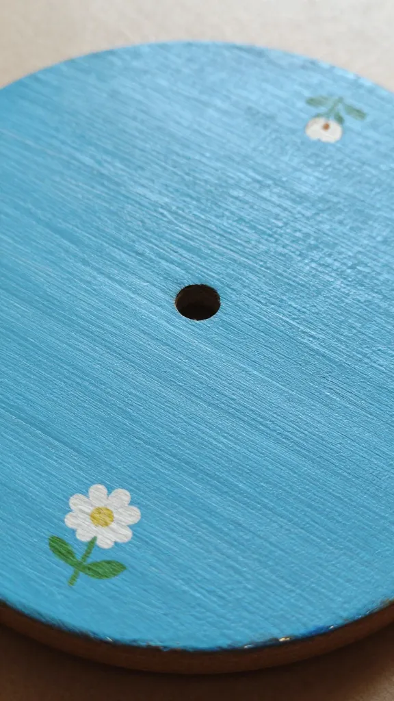 closeup of painted wooden coaster with tiny decals