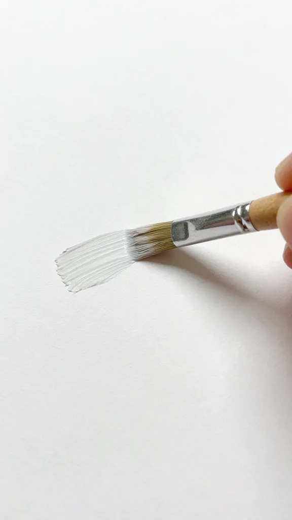 Closeup of a child’s paintbrush stroke on white paper surface